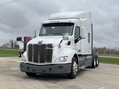 Peterbilt 579 semi-truck in white, conventional sleeper, front grille, headlights, and dual rear axles visible.