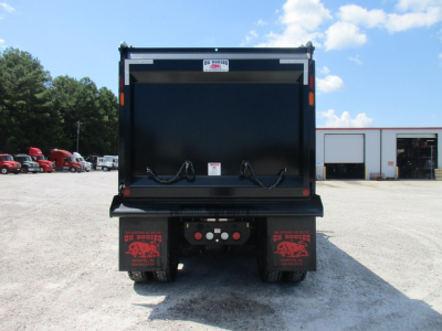 Dump truck bed of a 2027 Western Star 49X viewed from rear showing dump bed and mudflaps with branding.