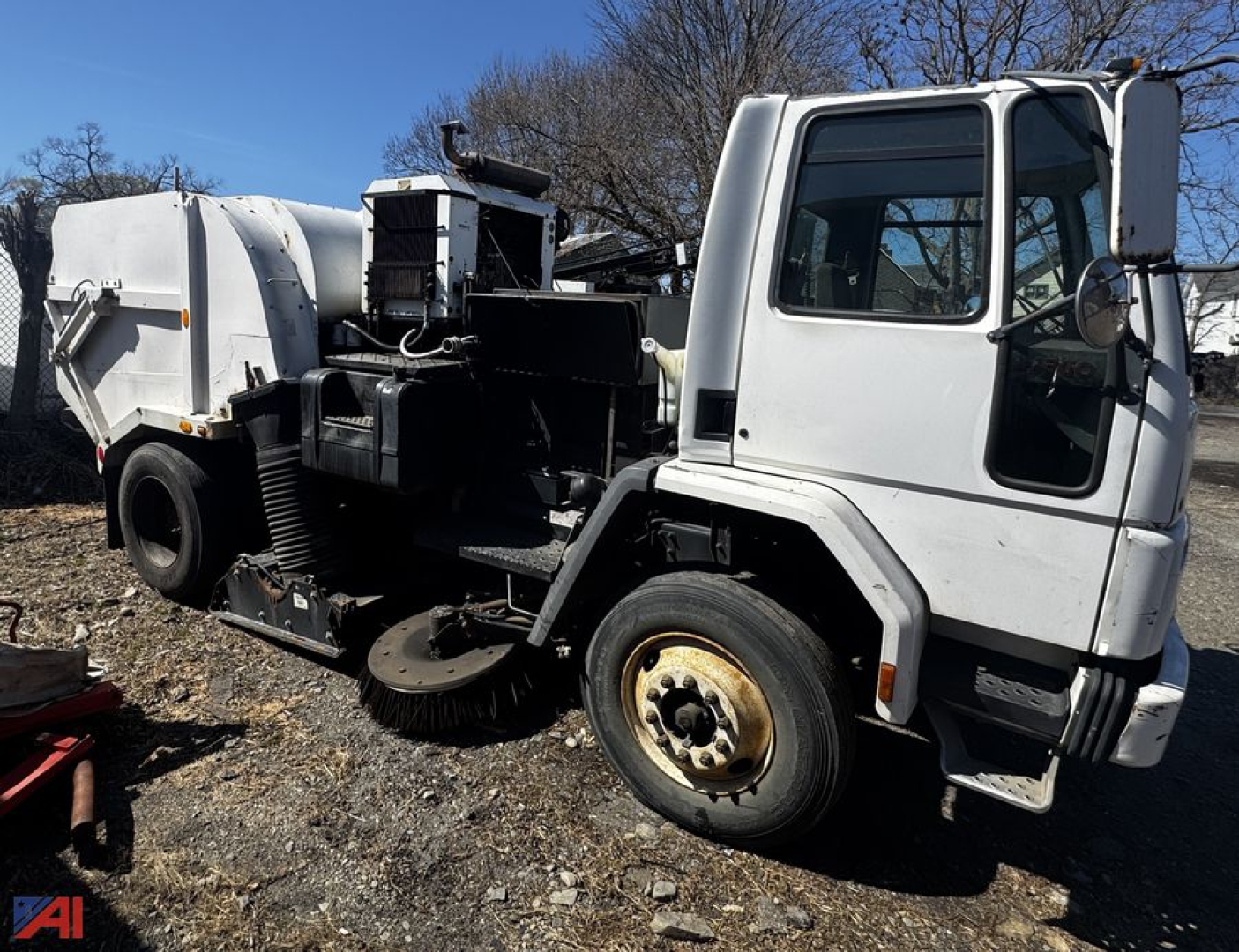 Freightliner FC70 sweeper truck in-service showing front cab and street sweeper attachment with large cylindrical debris container.