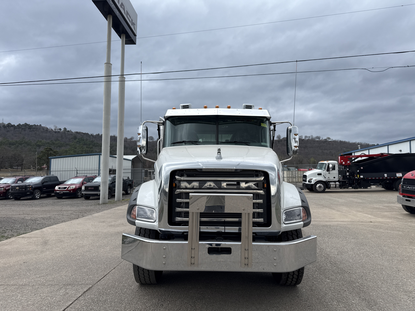 Front view of a new Mack GR64B roll-off truck showing large chrome grille, bumper guard, and RAM air intake.