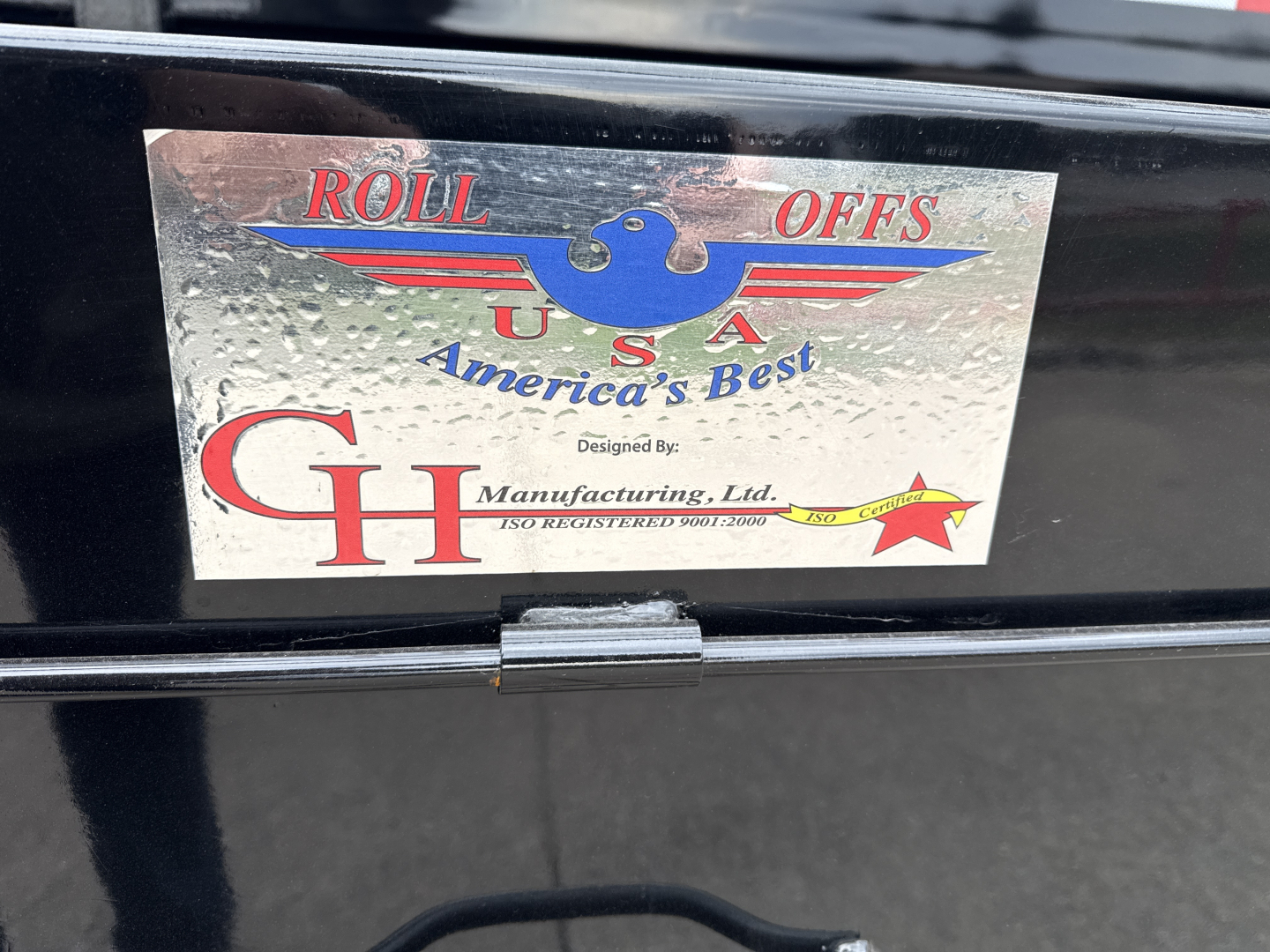CHD Roll Offs USA emblem plate on Mack GR64B truck showing Roll Offs USA America's Best and CH Manufacturing logo