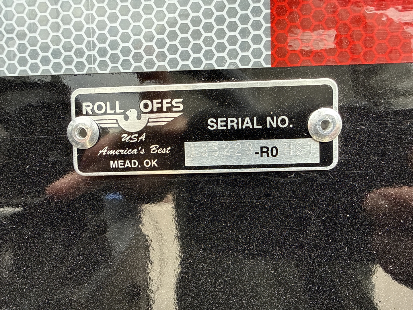 Roll-Offs serial plate showing Roll Offs USA America's Best MEAD, OK with serial number plate on black surface.
