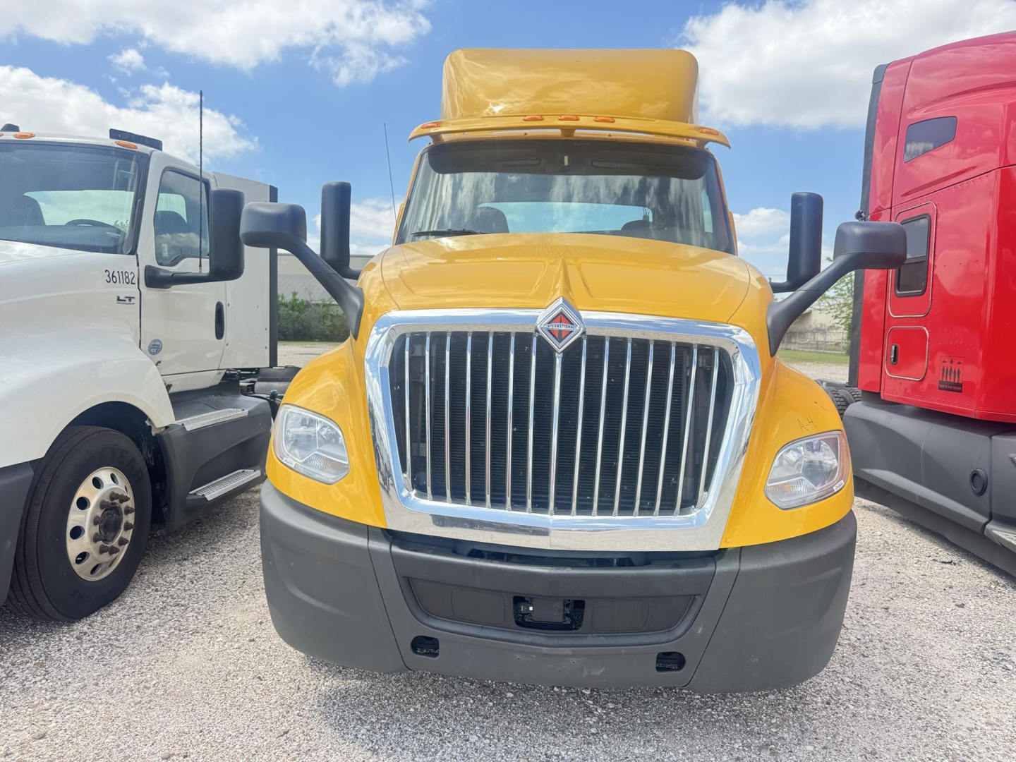 Front view of a yellow 2019 International LT conventional daycab truck showing large chrome grille, black bumper, and side mirrors.