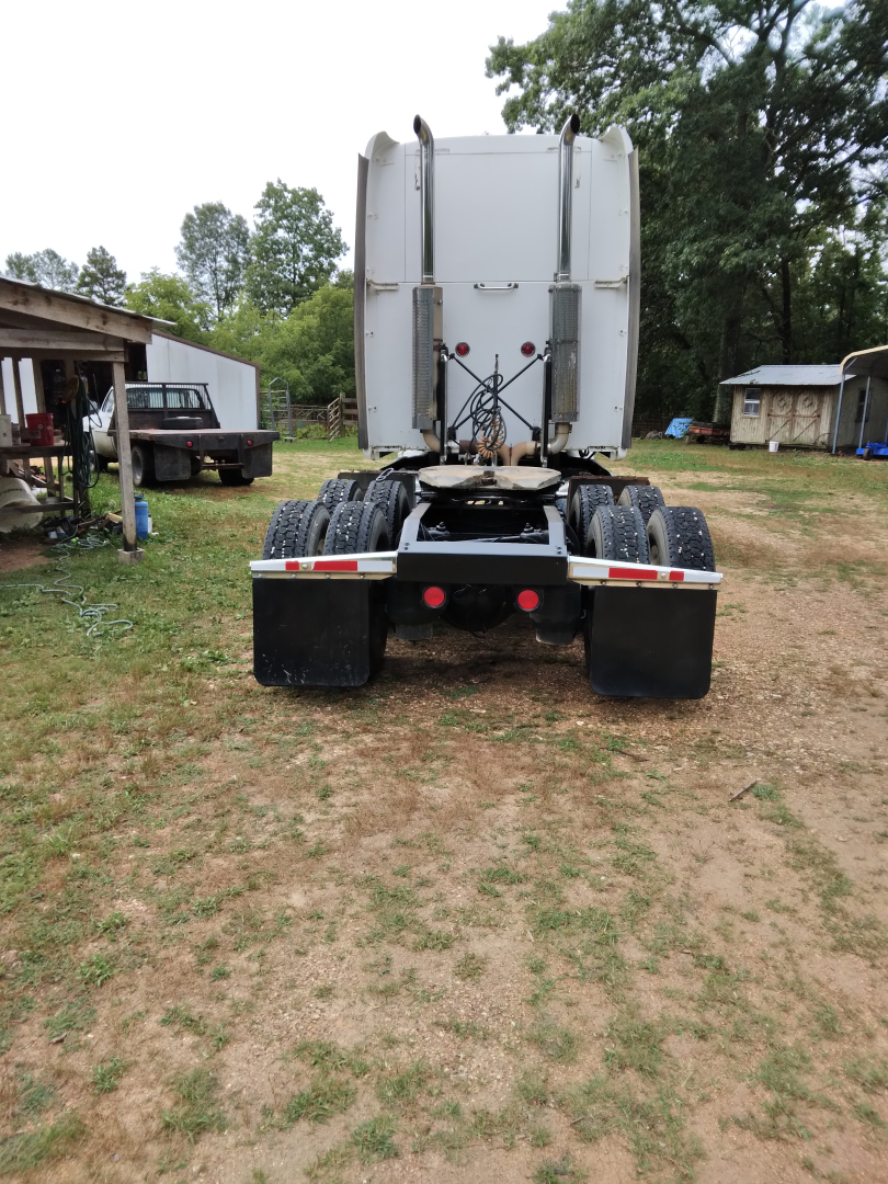 Truck rear view showing fifth wheel and dual rear axles of a Peterbilt 387 conventional sleeper.