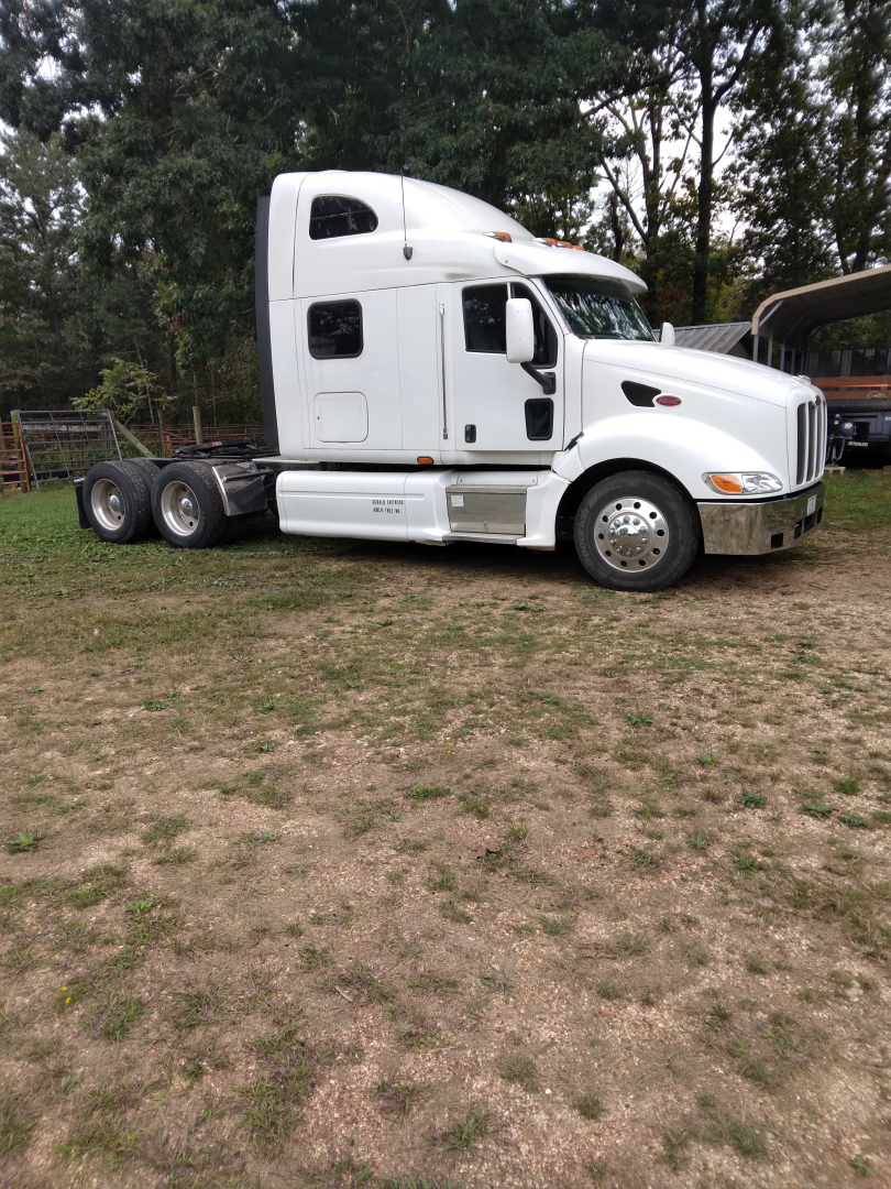 Peterbilt 387 conventional sleeper semi-truck in profile view, white cab, dual rear axles, fifth-wheel area visible, no trailer attached.