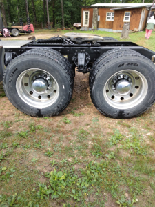Dual rear wheels of a Peterbilt 387 truck chassis showing large tires and chrome center caps.