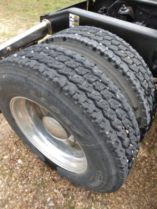 Peterbilt 387 chassis showing dual rear wheels with heavy-duty truck tires and polished aluminum rims.