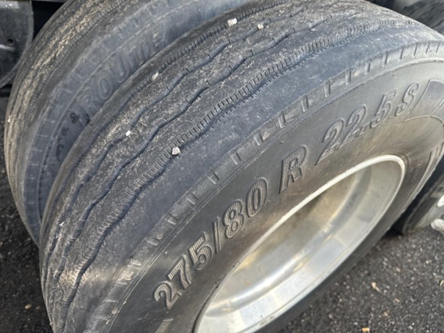 Tire close-up on a 2022 Utility Steel Flatbed trailer showing a dual-wheel setup with tread and tire markings 275/80R22.5