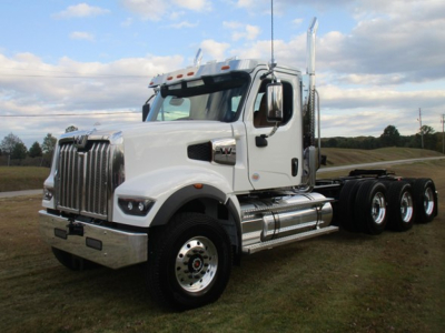 White Western Star 49X day cab truck with chrome bumper and dual rear axles, parked on grass under blue sky.