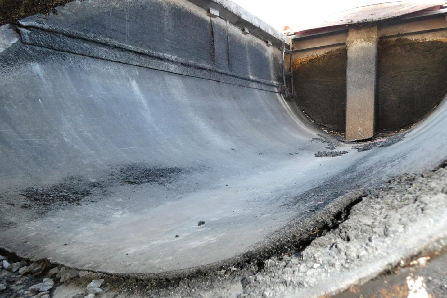 Dump truck bed interior showing coated metal surface and edge with some soil; looks like a used 2000 Mack RD688S dump truck. Text not visible.