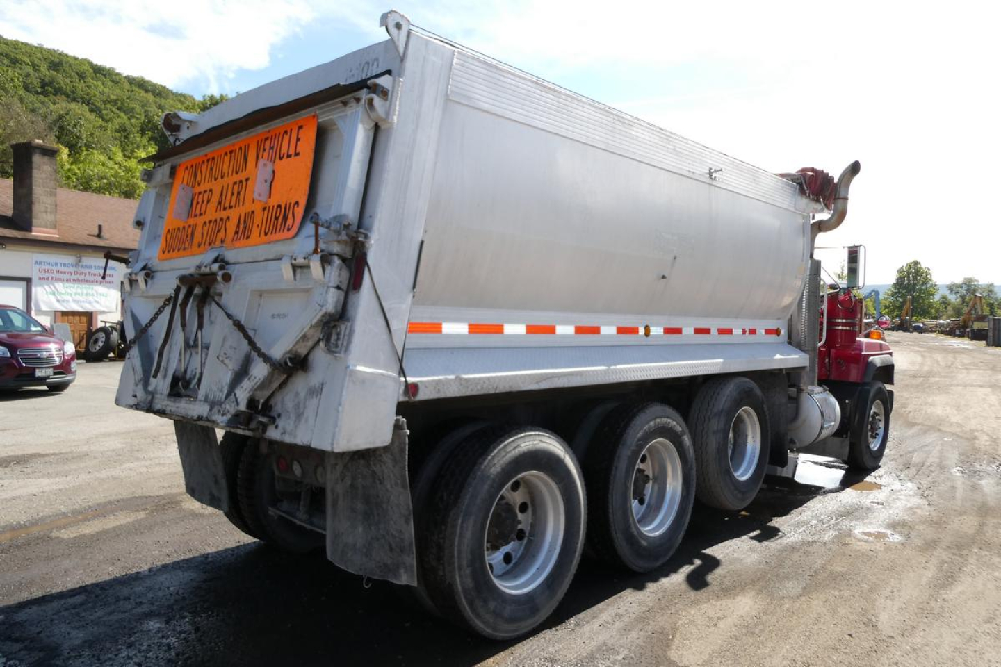 2000 Mack RD688S dump truck side/rear view showing dump bed, signage plate, and triple-axle arrangement.