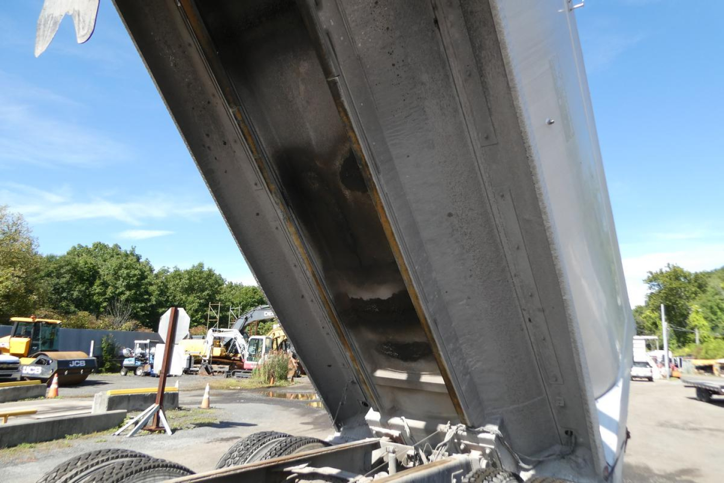 Dump truck bed in raised position showing metal framework and hydraulic hinge for Mack RD688S truck bed.