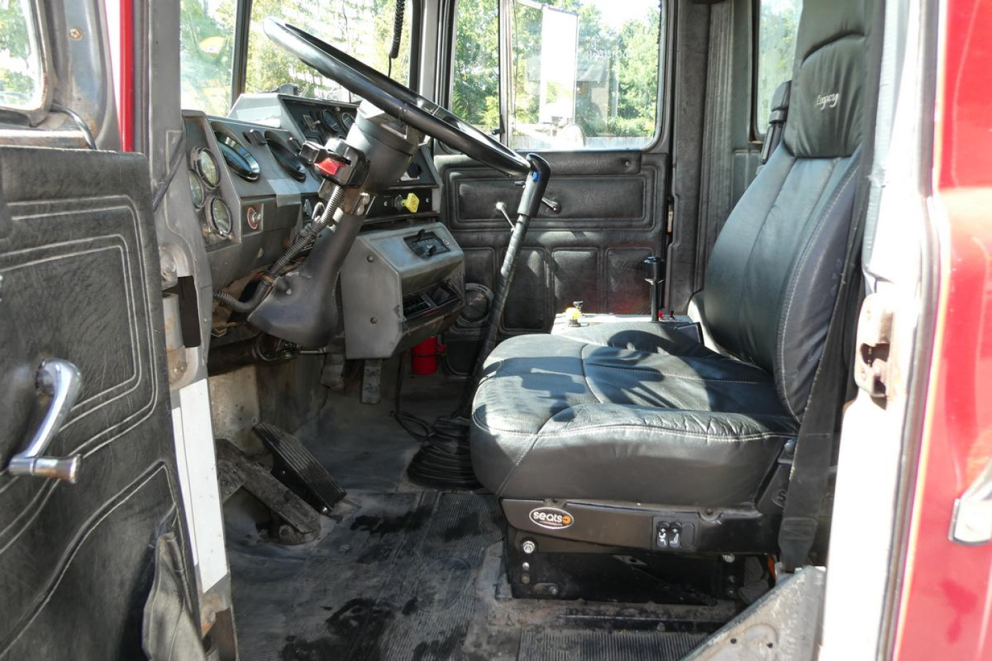 Truck cab interior showing driver seat and dashboard of a Mack RD688S dump truck.