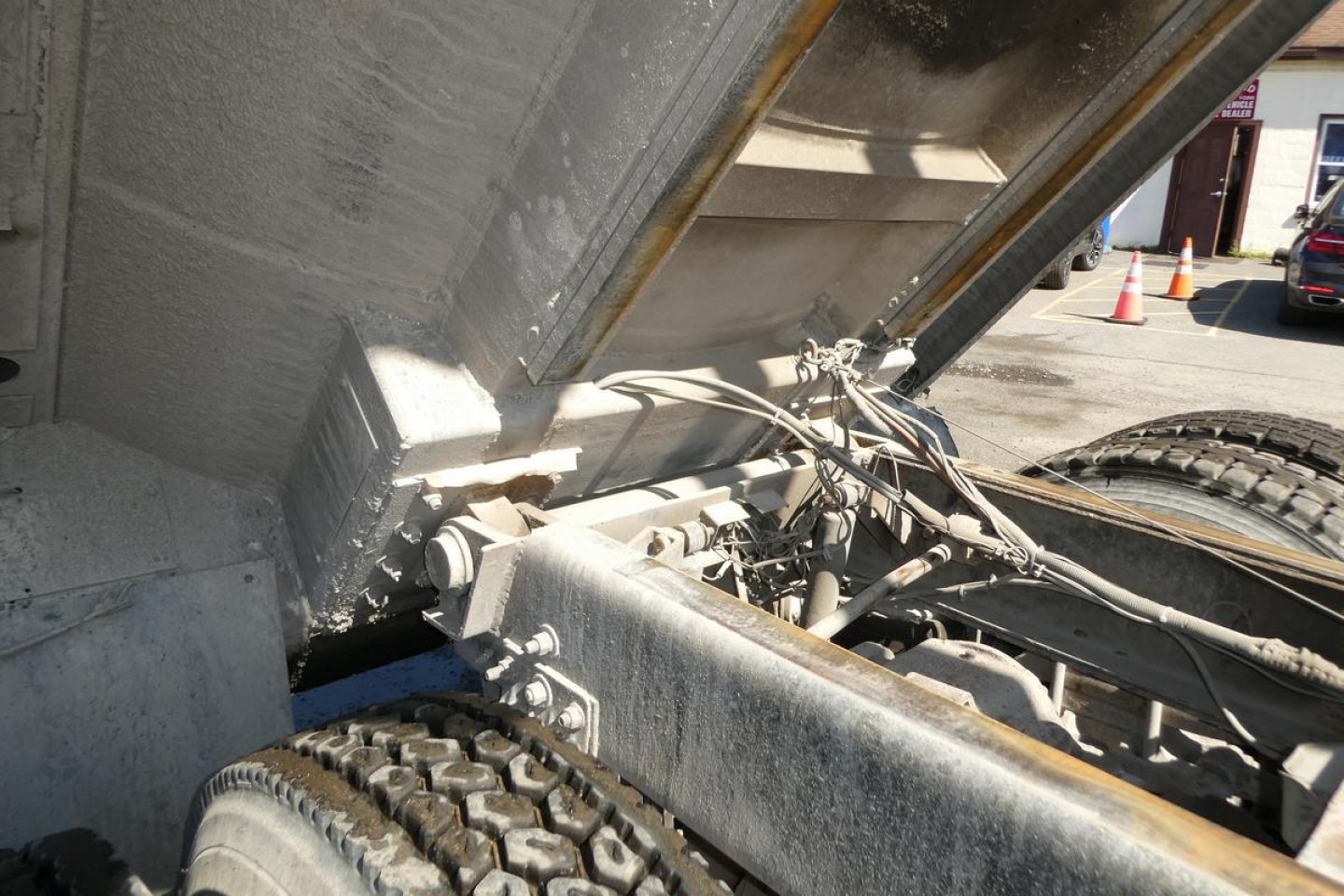 Measurement and wheel assembly of a Mack RD688S dump truck showing chassis, hydraulic linkages, and tires.