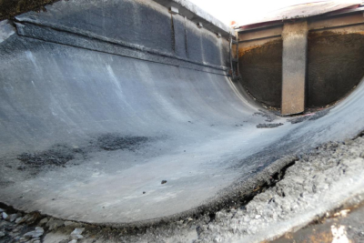 Dump truck bed interior showing coated metal surface and edge with some soil; looks like a used 2000 Mack RD688S dump truck. Text not visible.