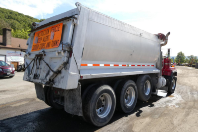 2000 Mack RD688S dump truck side/rear view showing dump bed, signage plate, and triple-axle arrangement.