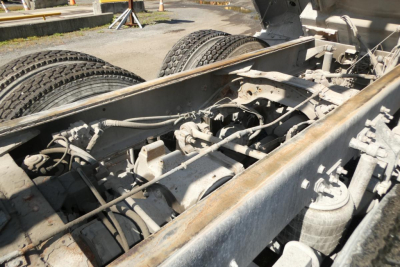 Truck chassis showing rear drivetrain and suspension components of a Mack RD688S dump truck, with dual rear wheels and exposed undercarriage.