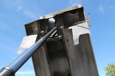 Mack RD688S dump truck component showing hydraulic lifting mechanism with steel framework and lift arm.