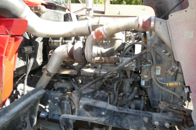 Mack RD688S diesel engine bay showing intercooler piping and turbocharger hoses with metal exhaust manifold and surrounding support frame.