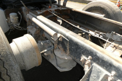 Truck chassis and suspension components of a Mack RD688S, showing frame rails, leaf springs, and drum brake hub.