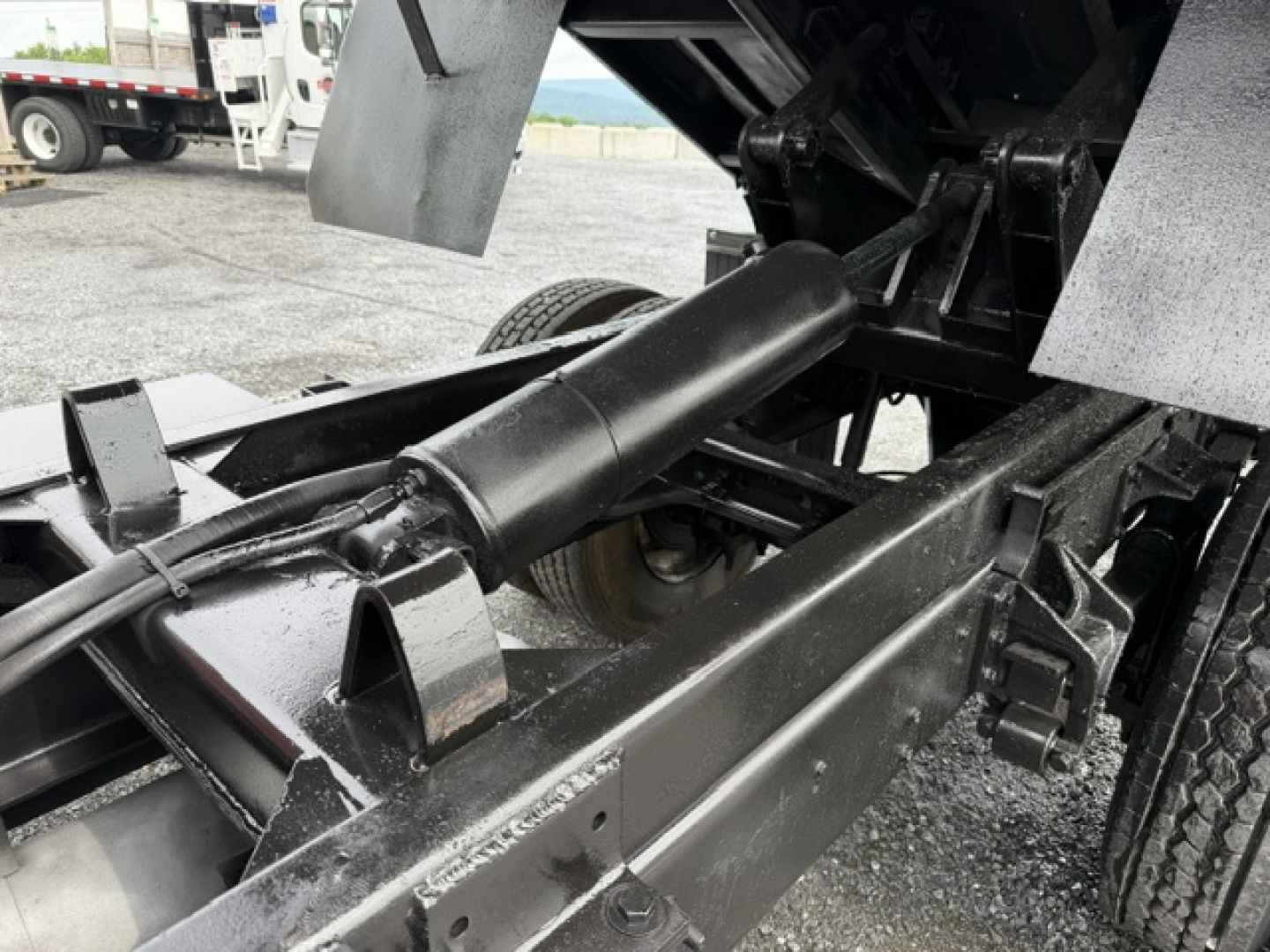 Truck chassis of a 2006 Ford F750 dump bed showing hydraulic cylinder and frame rails.