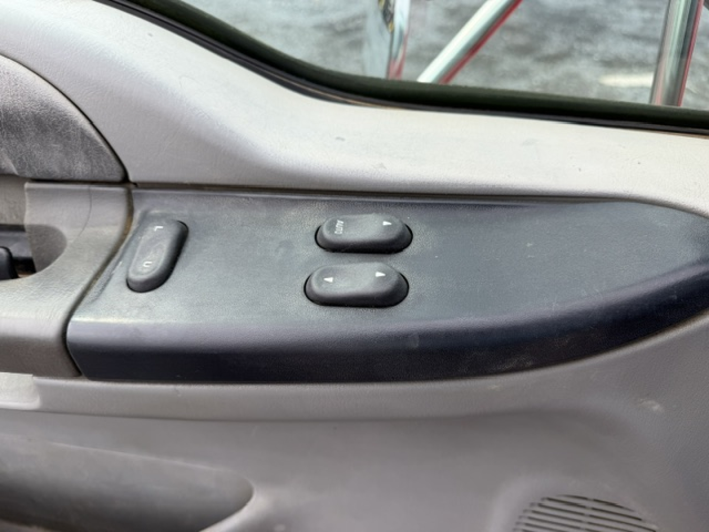 Truck interior door panel with power window switch and mirror controls on Ford F750 cab.