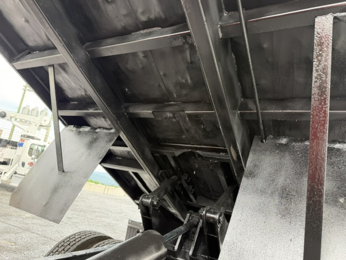 Ford F750 dump truck bed interior showing hydraulic mechanism and side panels.