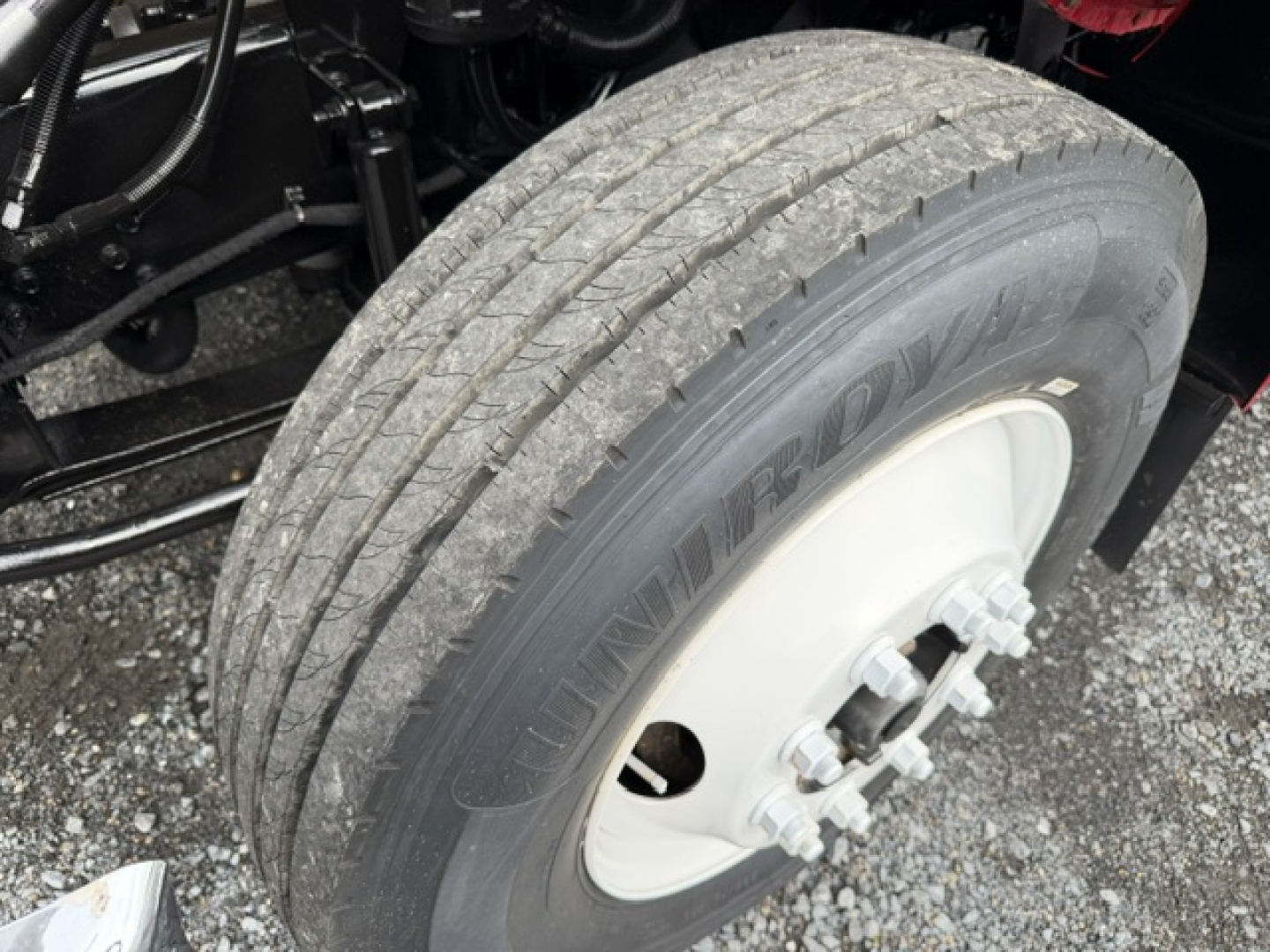 Ford F750 dump truck front wheel showing Dunlop tire and white wheel hub.