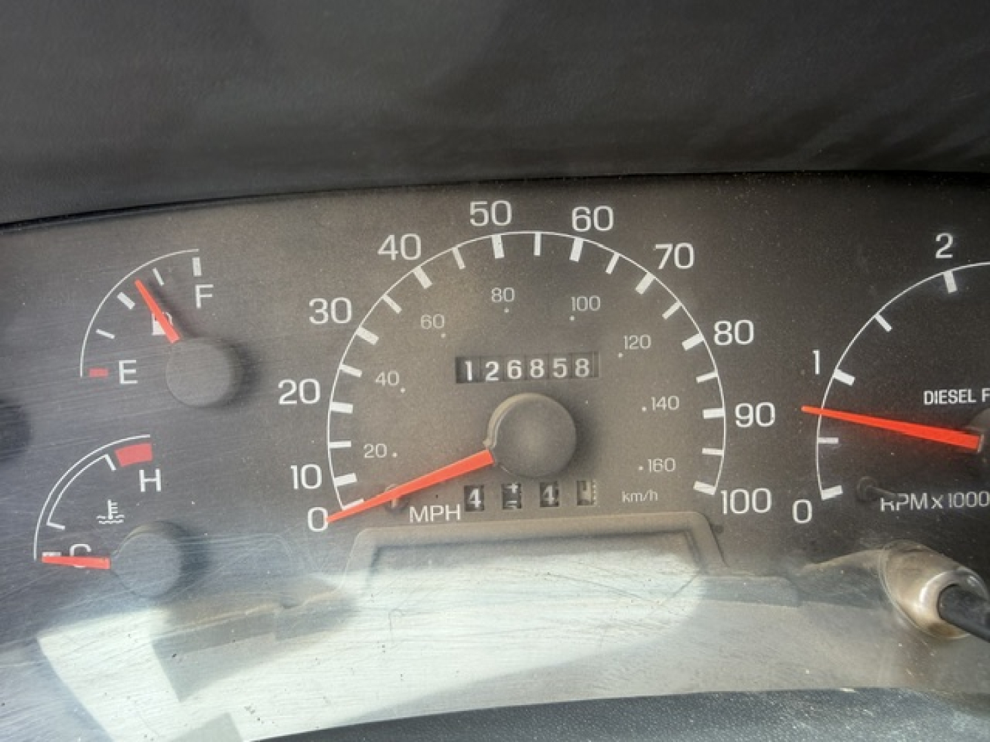 Instrument cluster showing odometer 126,858 miles on Ford F-750 gauge panel with speedometer, fuel gauge, coolant temp, and tachometer.