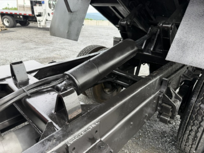 Truck chassis of a 2006 Ford F750 dump bed showing hydraulic cylinder and frame rails.