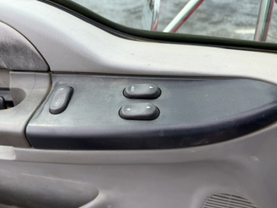 Truck interior door panel with power window switch and mirror controls on Ford F750 cab.
