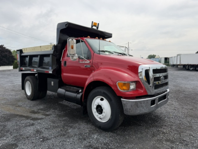 Red Ford F-750 dump truck with black dump bed, front chrome grille, and amber warning light on cab roof. VIN 3FRNF75R76V295637, stock 12885.