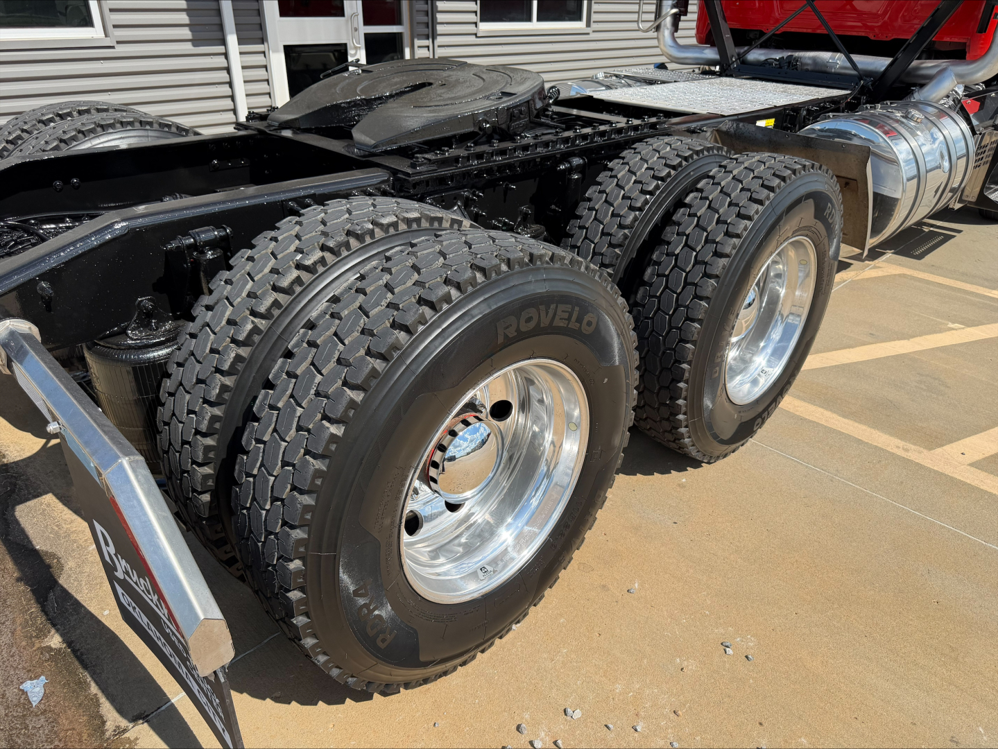 Dual rear tandem wheels on a 2022 Mack ANTHEM truck showing heavy-duty ROVLO tires and polished aluminum rims; fuel tank and sideframe visible in background.