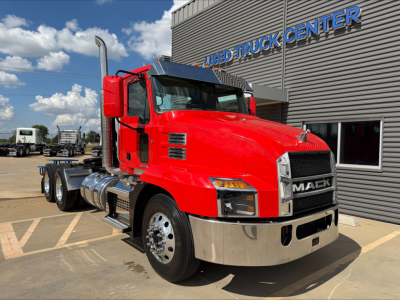 Red 2022 Mack Anthem truck in front of dealership building with chrome bumper and large grille.