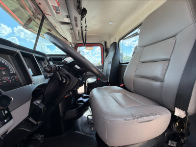 Mack Anthem interior left-side view showing driver seat and steering wheel with dashboard gauges and overhead console.