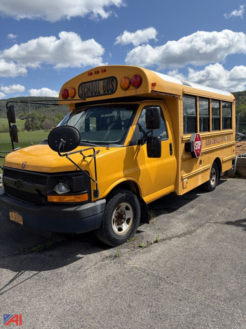 School bus in-service showing yellow Chevrolet Express body with stop sign, side lettering, and school bus markings on the door and rear quarter panel.