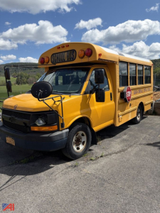 School bus in-service showing yellow Chevrolet Express body with stop sign, side lettering, and school bus markings on the door and rear quarter panel.