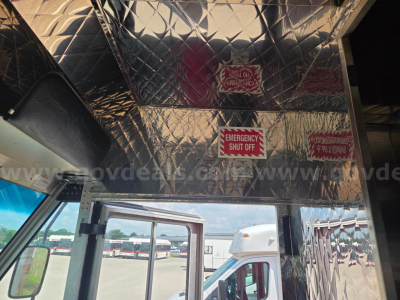 Truck interior dash area with diamond plate aluminum ceiling panels and emergency shut-off signs.