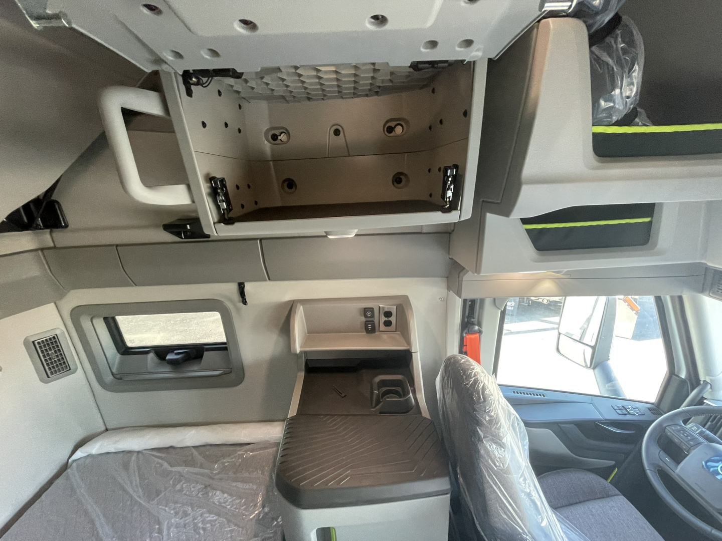 Volvo VNL64T860 cab interior showing overhead storage compartment and dashboard area with cups and panels.