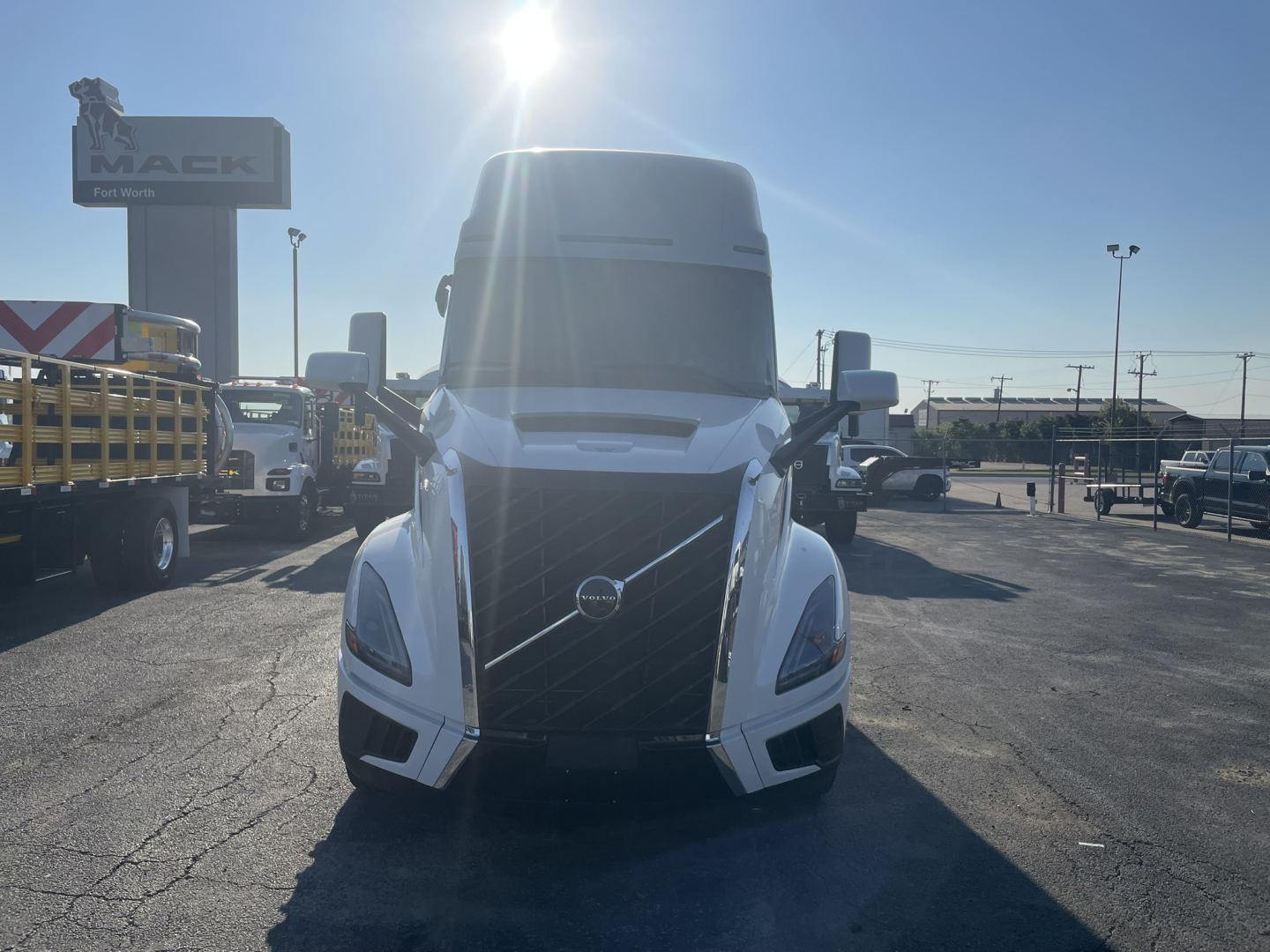 Front view of a new 2026 Volvo VNL64T860 truck in a dealership lot with other trucks in background.