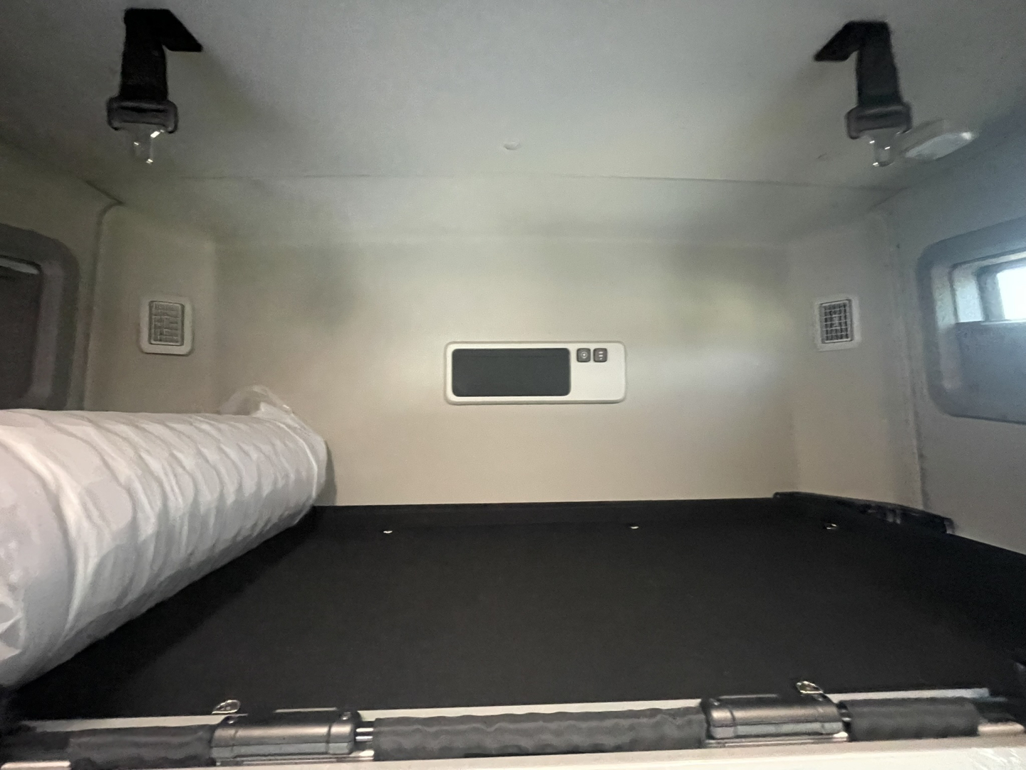 Volvo VNL64T860 sleeper cab interior loft bed area with storage and side vents visible.