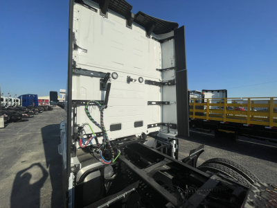 Volvo truck tractor cab rear wall with wiring harness and chassis rails visible in a yard.