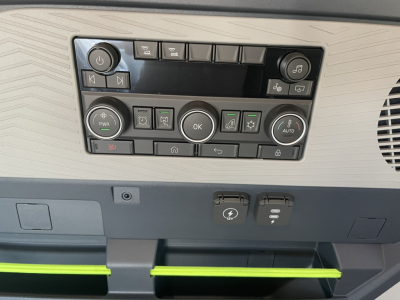 Volvo VNL64T860 cockpit control panel showing various buttons and knobs in beige dashboard with green accents.