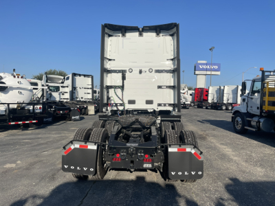 Rear view of a 2026 Volvo VNL64T860 truck tractor with fifth wheel and dual rear axles, Volvo mud flaps, and trailer hitch area visible.