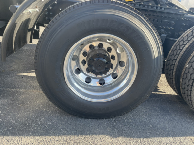 Wheel and tire close-up from a Volvo VNL64T860 truck showing the Bridgestone tire on a polished aluminum wheel with lug nuts.