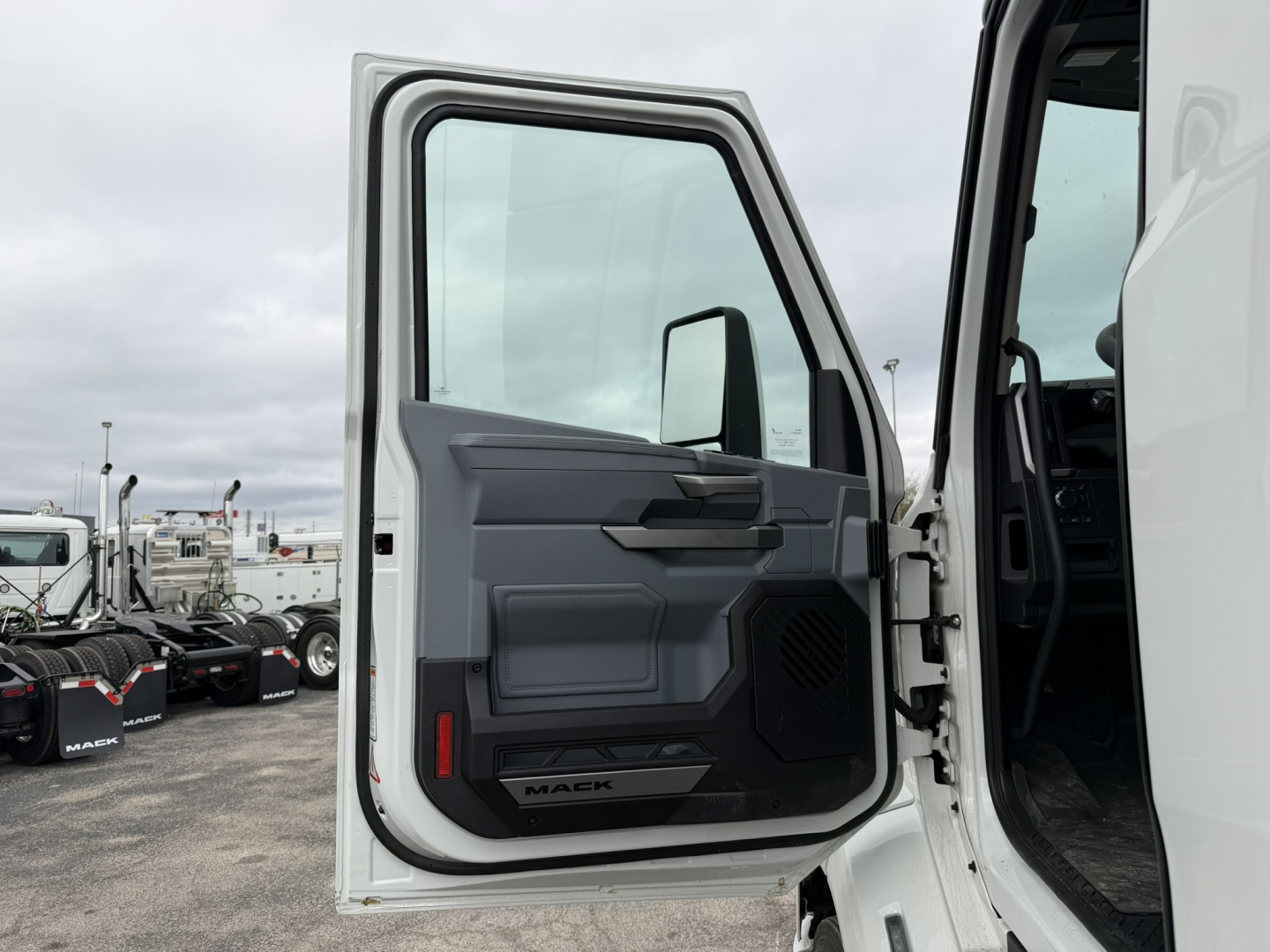 Mack AN64T truck cab entry showing open door and interior panel with speaker grille and 'MACK' badge visible near the sill.