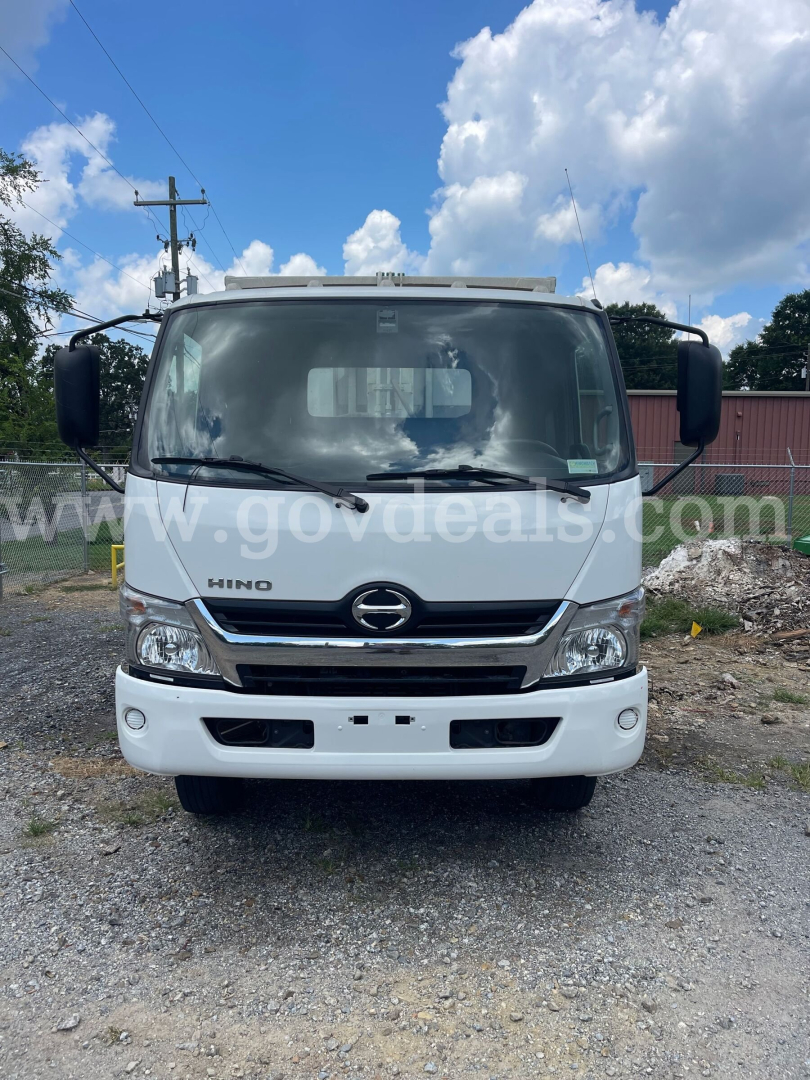 Hino 195 truck front view showing grille, headlights, and bumper with Hino emblem.