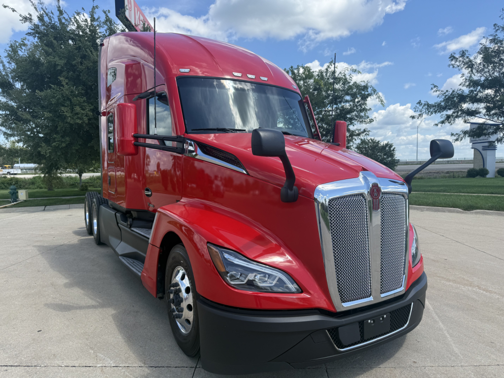 Kenworth T680 sleeper cab truck in red, front 3/4 view showing chrome grille, headlights, and side mirrors.