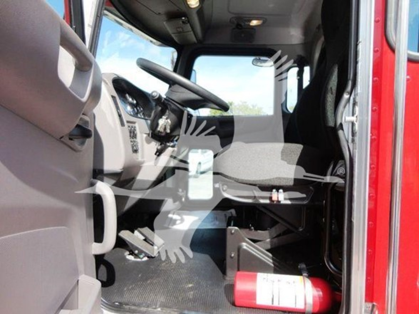 Trucks cab interior of 2022 Peterbilt 337 rollback showing steering wheel, dashboard, driver's seat, and fire extinguisher mounted near floor.