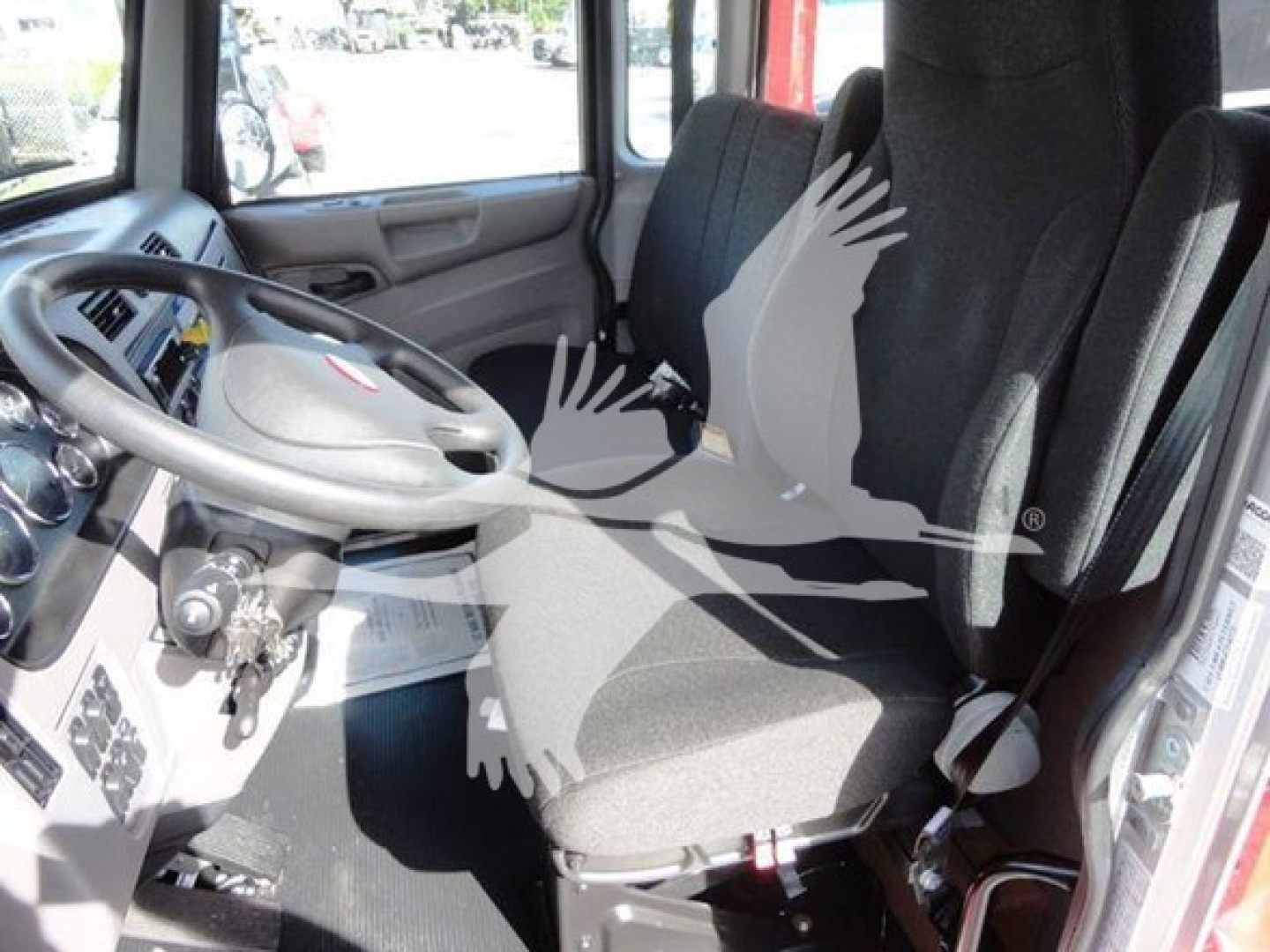 Peterbilt 337 cab interior showing steering wheel, driver's and passenger seats, dashboard controls, and driver-side door; image displays truck cab with gear area and seating.